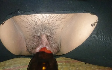 Horny Thai girl takes a bottle and stuffs it into her clit.